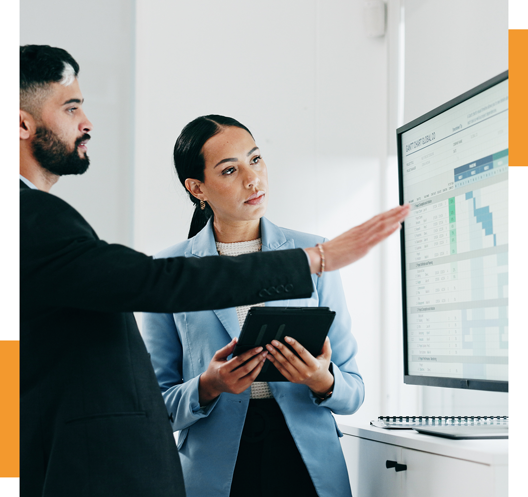 Two professionals analyzing data on screen.