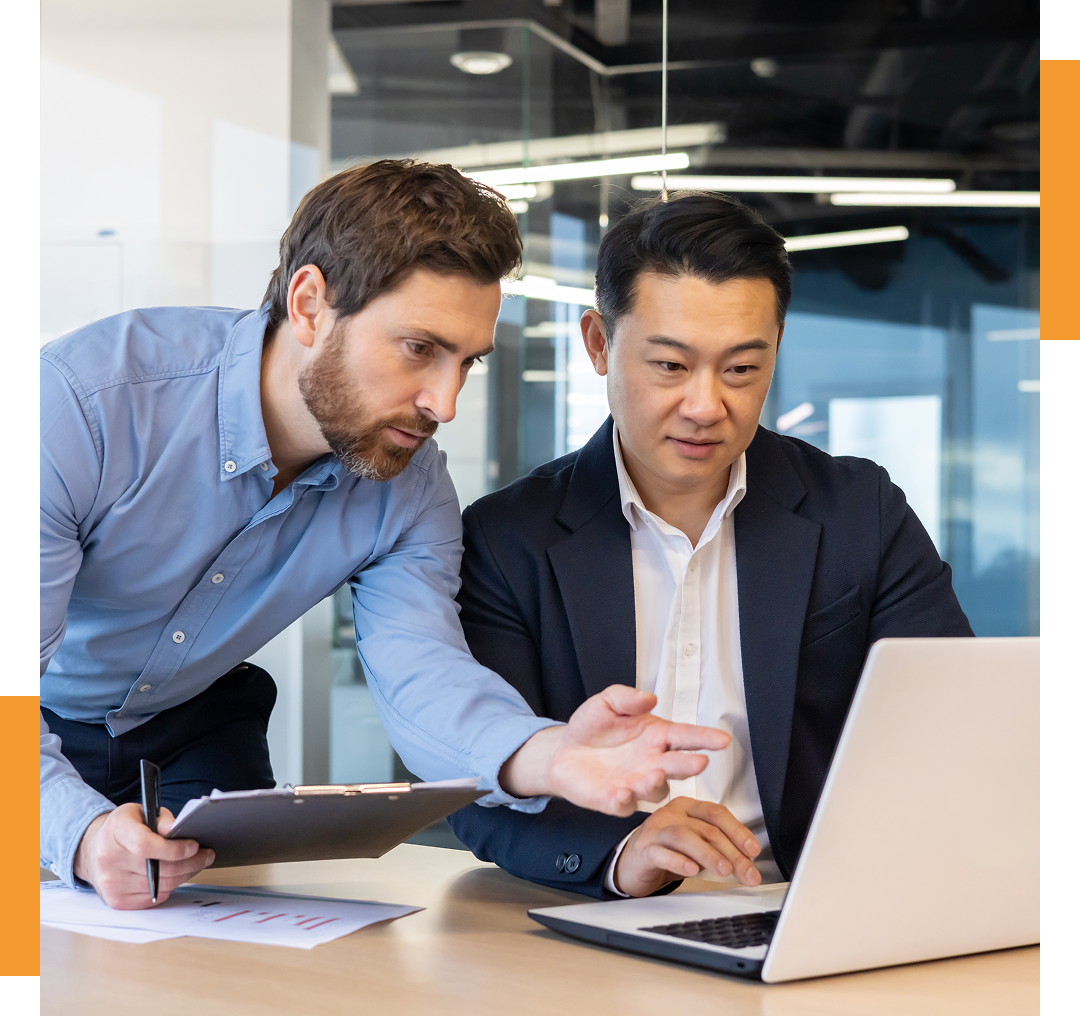 Two businessmen collaborating over a laptop.