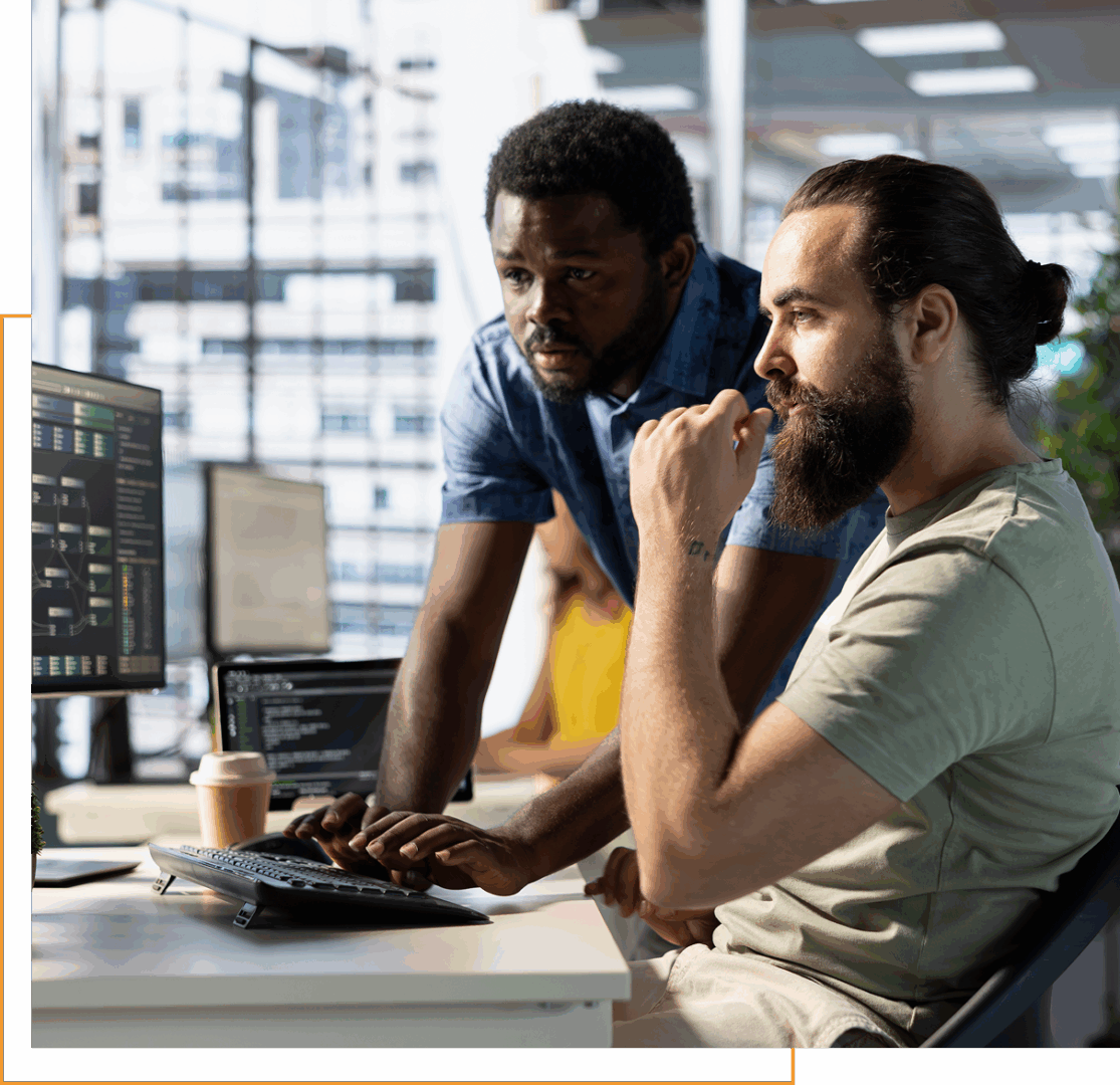 Two men collaborating at a computer desk.