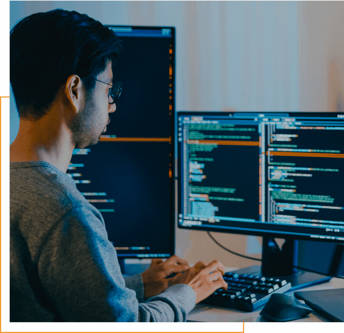 Person coding on dual monitors, focused work.