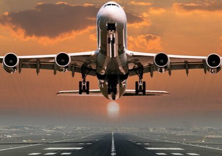 A plane flying low to the ground on an airport runway.
